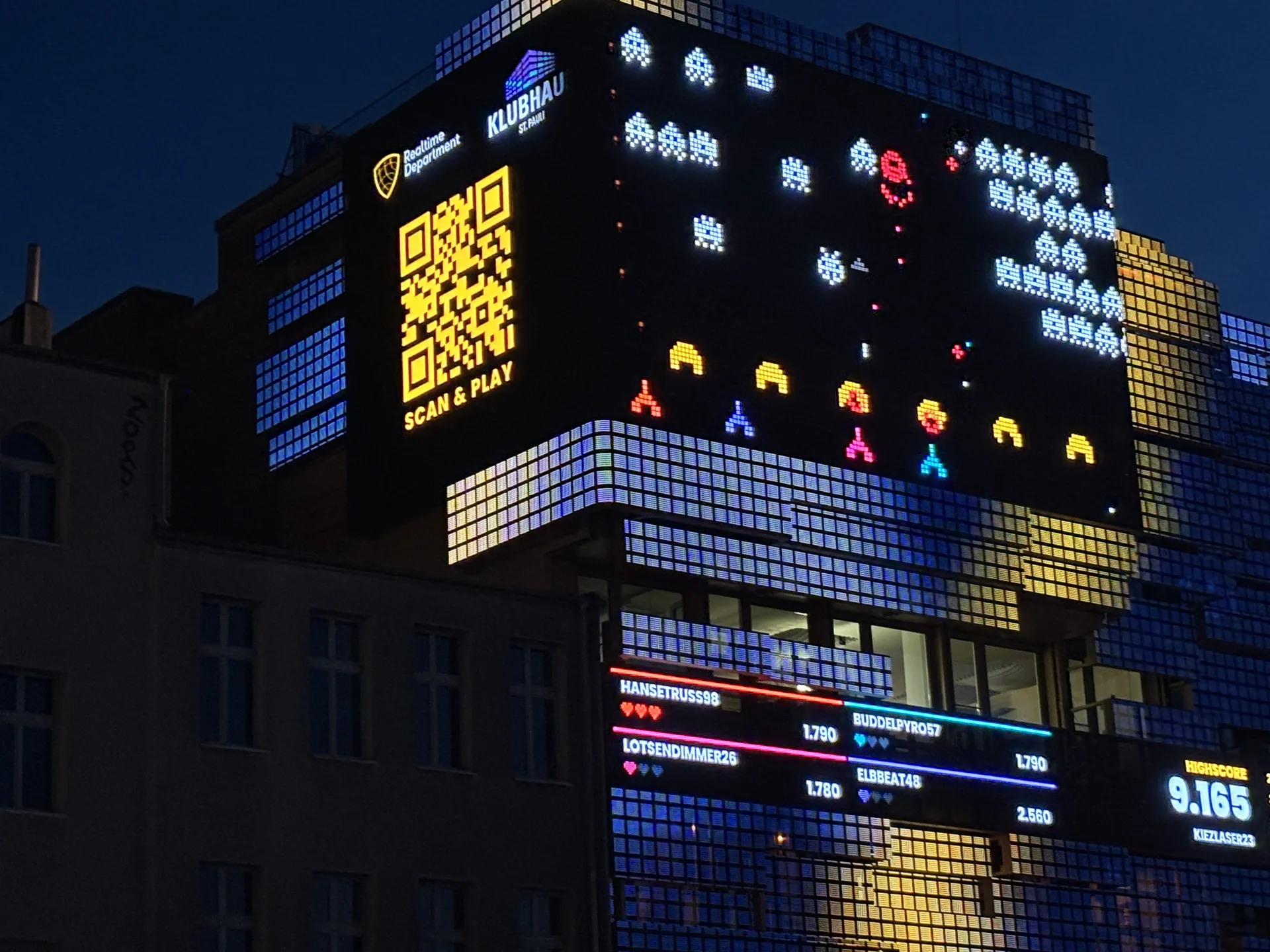Spielfeld mit QR-Code „Scan & Play“ auf der Fassade